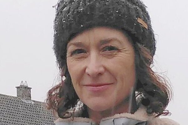 LibDem campaigner Cathy Bryan head and shoulders, in a woolly hat on a  snowy day