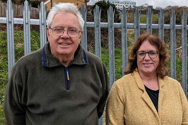 Graham Amy with Newhaven Town Councillor Kim Bishop standing in front of a fence with buildings in the background