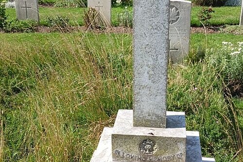 A headstone in the shape of a cross on a plinth, the stone weathered, and surrounded by untended grass and weeds. The inscription reads "In loving memory, my dear husband Edward Sibun Hornblower of the 87th Batt Canadians M.C.S. Born Novr 13th 1873 died on active service March 22nd 1917. Also of..." Further words are obscured by the grass.