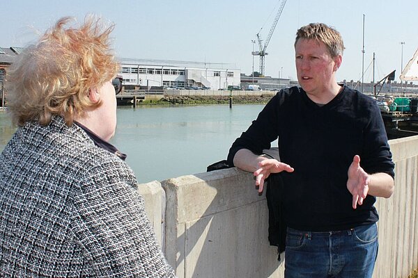 James MacCleary explaining a point with the river and cranes in the background.