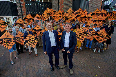 James MacCleary and Ed Davey both looking very happy in front of a sea of LibDem diamond posters