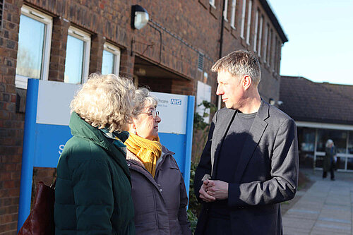 James talking to residents outside an NHS facility