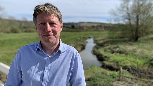 James on a sunny day with the Cuckmere river behind him.