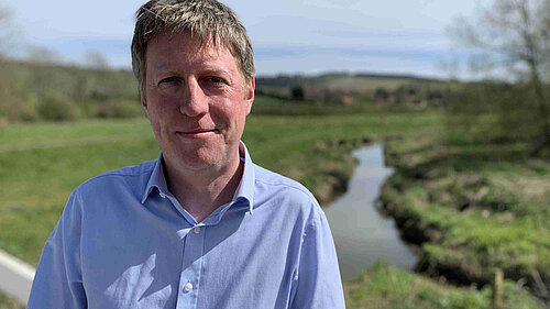 James on a sunny day with the Cuckmere river behind him.