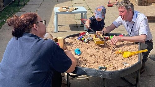 James with a nursery worker and a child playing with a raised sandpit (good practice for the House of Commons)